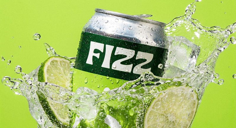 Green soda can splashing through ice and lime slices on a green backdrop