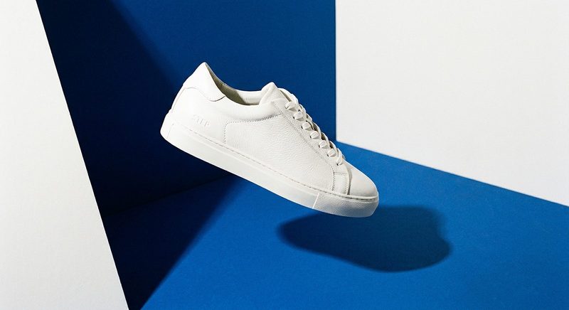 White leather sneaker suspended in a cobalt-blue geometric set