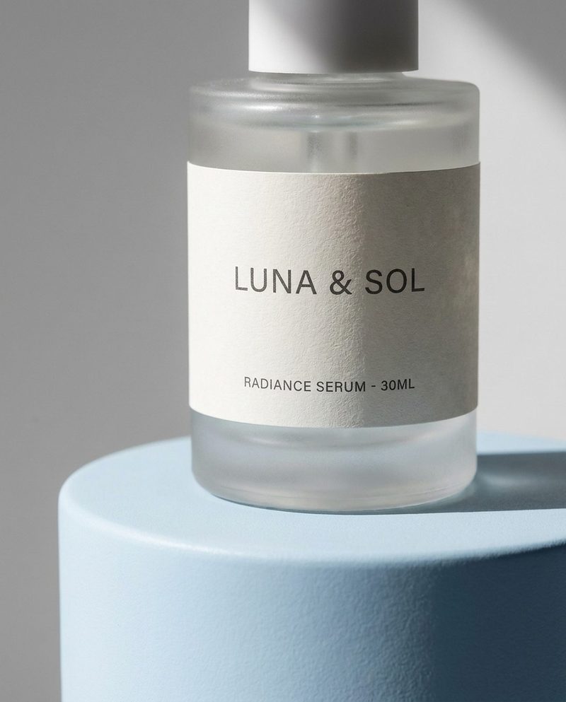 Close-up of a frosted-glass serum bottle on a pale blue pedestal